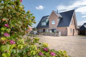 una gran casa de ladrillo con techo negro en Bäum Hüs B, en Westerland