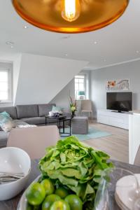 uma sala de estar com uma mesa com uma tigela de verduras em Bäum Hüs B em Westerland