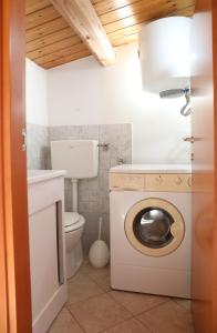 a bathroom with a washing machine and a toilet at Verande in Sampieri