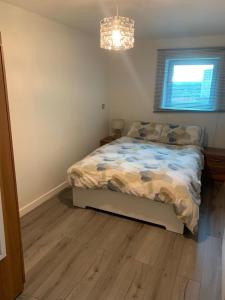 a bedroom with a bed and a chandelier at 2 Bed duplex, close to Millennium Square in Leeds
