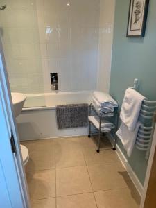 a bathroom with a tub and a toilet and a sink at 2 Bed duplex, close to Millennium Square in Leeds