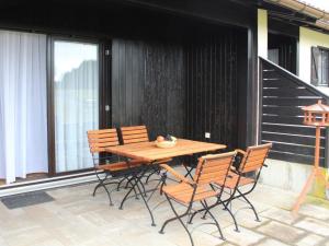 einen Holztisch und Stühle auf dem Balkon in der Unterkunft Ferienhaus Nr 110, Typ A, Feriendorf Hochbergle, Allgäu in Karlsebene