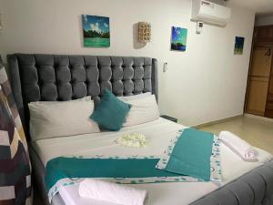 1 dormitorio con 1 cama grande y cabecero gris en Lux Suites Lamera Beachfront Apartments, en Shanzu