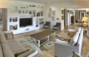 uma sala de estar com mobiliário branco e uma televisão de ecrã plano em Villa Des Vincenty em Uchaux