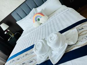 Una cama con toallas y un arco iris. en Vortex Suites Klcc by Rit Villa en Kuala Lumpur