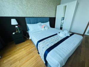 a bedroom with a large bed with two towels on it at Vortex Suites Klcc by Rit Villa in Kuala Lumpur