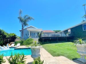 a house with a swimming pool and palm trees at North Breeze Retreats in Durban