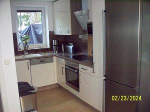 eine Küche mit einem Kühlschrank aus Edelstahl und einem Fenster in der Unterkunft Villa Rogge in Berlin