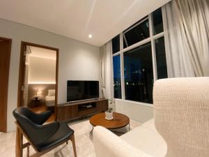 Sky Suites & Residence KLCC Kuala Lumpur في كوالالمبور: غرفة معيشة بها أريكة بيضاء وتلفزيون