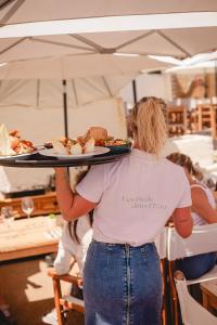 eine Person, die ein Tablett mit Essen auf einem Tisch hält in der Unterkunft Salines in Hyères