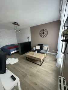 a living room with a couch and a table at Studio Cosy Elancourt, Les terrasses d'Héricé in Élancourt