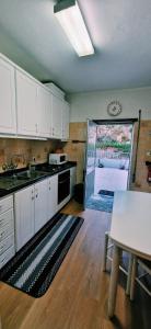 a kitchen with white cabinets and a table and a door to a patio at Casa Rodrigues in Pinhão