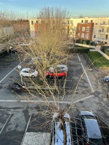 un estacionamiento con autos estacionados en un estacionamiento en Studio Cosy Elancourt, Les terrasses d'Héricé, en Élancourt