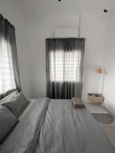 a large bed in a bedroom with curtains at The White Sands Homestay Pekan Pahang in Pekan
