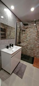 a bathroom with a white sink and a brick wall at Casa Rodrigues in Pinhão