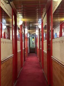 an empty hallway with red doors and a red carpet at Den Röda Båten in Stockholm