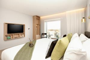 Un dormitorio con una gran cama blanca y un televisor. en Wilde Aparthotels London Paddington, en Londres 41 fotos más