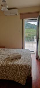 a bedroom with a bed and a large window at Casa Rodrigues in Pinhão
