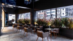 a restaurant with tables and chairs and plants at The Prima Hotel Jongno in Seoul +42 photos
