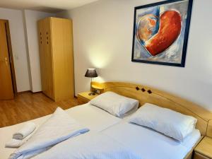 1 dormitorio con 1 cama con una pintura al corazón en la pared en Auszeit im Thierseetal, familienfreundliche Ferienwohnung, FeWo 7, en Thiersee