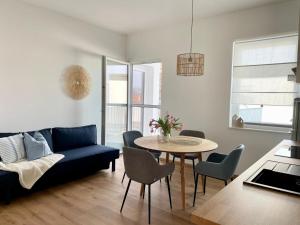 メルビッシュ・アム・ゼーにあるPannonia Apartmentsのリビングルーム(青いソファ、テーブル付)