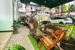 a patio with chairs and a couch and a table at Golden V Grandeuria Unit E in Malolos