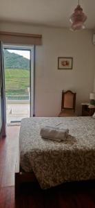 a bedroom with a large bed and a large window at Casa Rodrigues in Pinhão