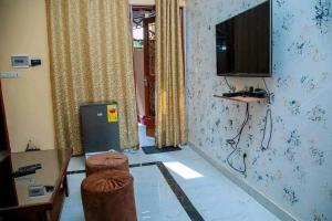 a living room with a television and a table and chairs at Eden Meublé in Ouagadougou