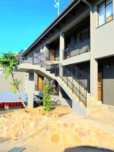 a building with stairs and balconies on the side of it at Royal Taste of Africa Apartments in Windhoek