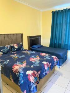 een slaapkamer met een bed met een blauw dekbed bij Royal Taste of Africa Apartments in Windhoek