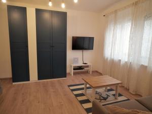 uma sala de estar com uma televisão e um sofá em Appartement blue Dinghi em Mörbisch am See