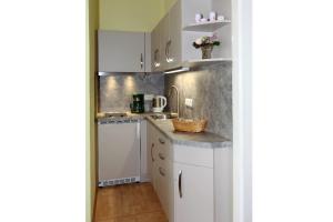 a kitchen with white cabinets and a counter top at Haus Waterkant in Breege +3 photos