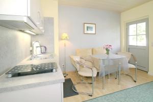 a kitchen and a dining room with a table and a kitchen at Haus Waterkant in Breege