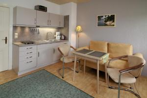 a kitchen with a table and chairs in a room at Haus Waterkant in Breege