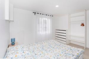 um quarto branco com uma cama e uma cómoda em Côté jardin 1 - Appartement avec Jardin em Le Coteau