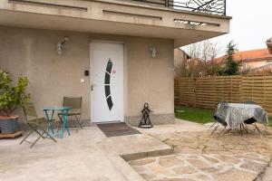 uma porta da frente de uma casa com uma mesa e cadeiras em Côté jardin 1 - Appartement avec Jardin em Le Coteau