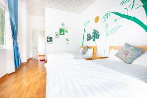 two beds in a room with white walls at Cat Ba Countryside Homestay in Cat Ba