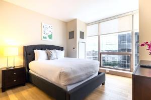 ein Schlafzimmer mit einem großen Bett und einem großen Fenster in der Unterkunft Spacious Apartment Downtown in Stamford