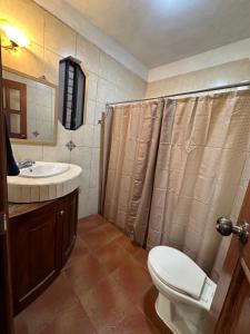 a bathroom with a toilet and a sink at Casa Alicia Hostal Antigua Guatemala in Antigua Guatemala