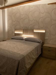 um quarto com uma cama com duas luzes em Casa Román em Albarracín