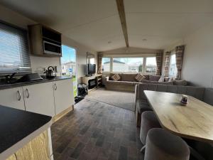 a kitchen and living room with a couch and a table at Lovely 6 Berth Caravan At Cherry Tree Holiday Park, Ref 70403c in Great Yarmouth