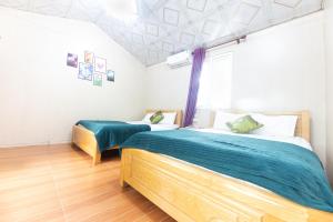 a bedroom with two beds and a window at Cat Ba Countryside Homestay in Cat Ba