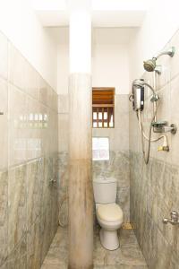 a bathroom with a toilet and a shower at SHYNI Guest House in Hikkaduwa