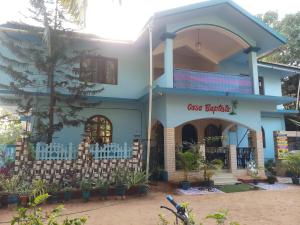 een blauw huis met een bord ervoor bij Casa Baptista Guest House in Goa