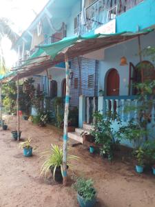 een blauw gebouw met een veranda met potplanten bij Casa Baptista Guest House in Goa