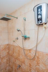 a shower in a bathroom with a shower head at SHYNI Guest House in Hikkaduwa
