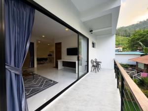 a balcony of a house with a view of a living room at New above Chaweng - Inkl Scooter in Amphoe Koksamui