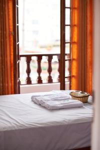 Una cama con dos toallas y una cesta. en Hostel Prada en Lima