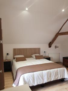 a bedroom with a large bed with white sheets at Mon Gîte in Château-du-Loir