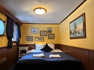 a bedroom with a bed with two towels on it at Den Röda Båten in Stockholm